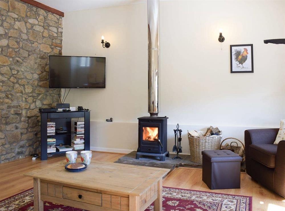 Delightful living area with exposed stone feature wall at Dairy Cottage, 