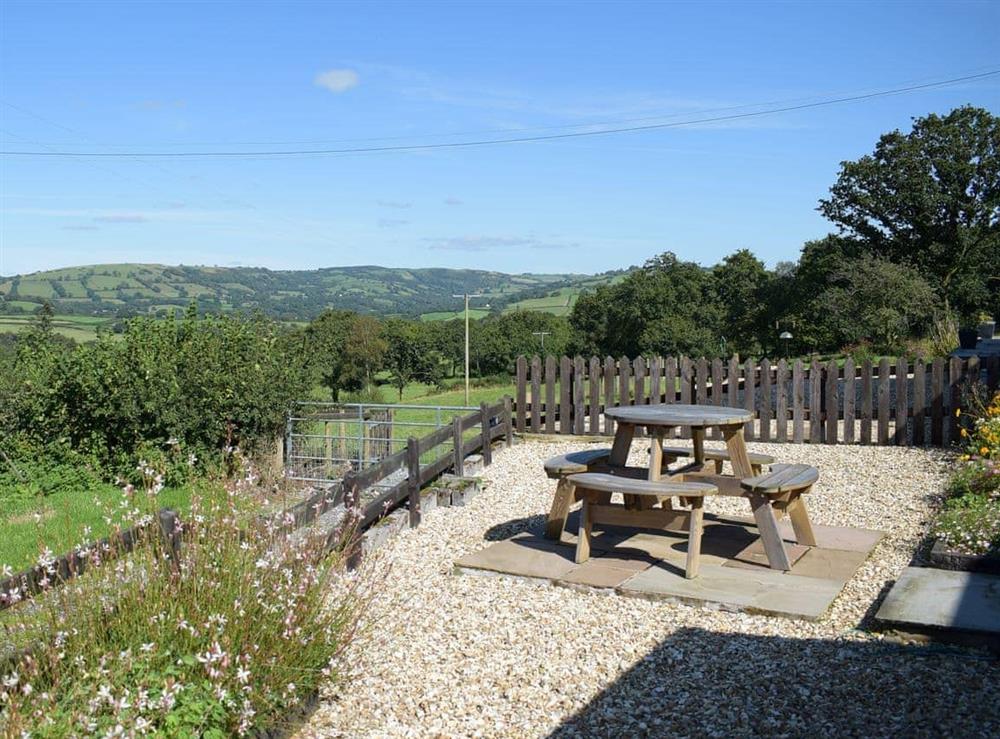 Gravelled patio with picnic-style table and chairs at Dairy Cottage, 