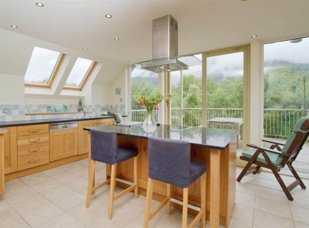Spacious and well-equipped kitchen area with French doors leading to the balcony at Carness West in West Carness, By Fort William., Inverness-Shire