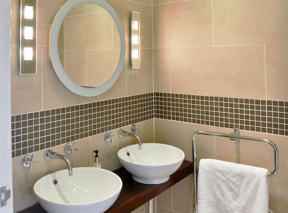 En-suite bathroom with over-bath shower, double basin and toilet at One Acre View, 