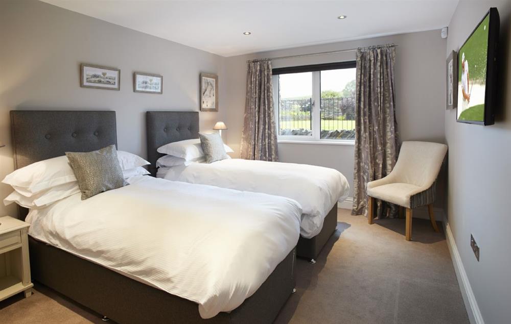 Bedroom Two with 6’ super king zip/link bed and en-suite shower room at Carus House, Burneside