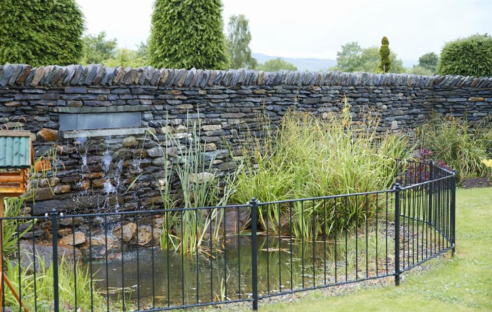 Large landscaped garden with water feature at Carus House, Burneside