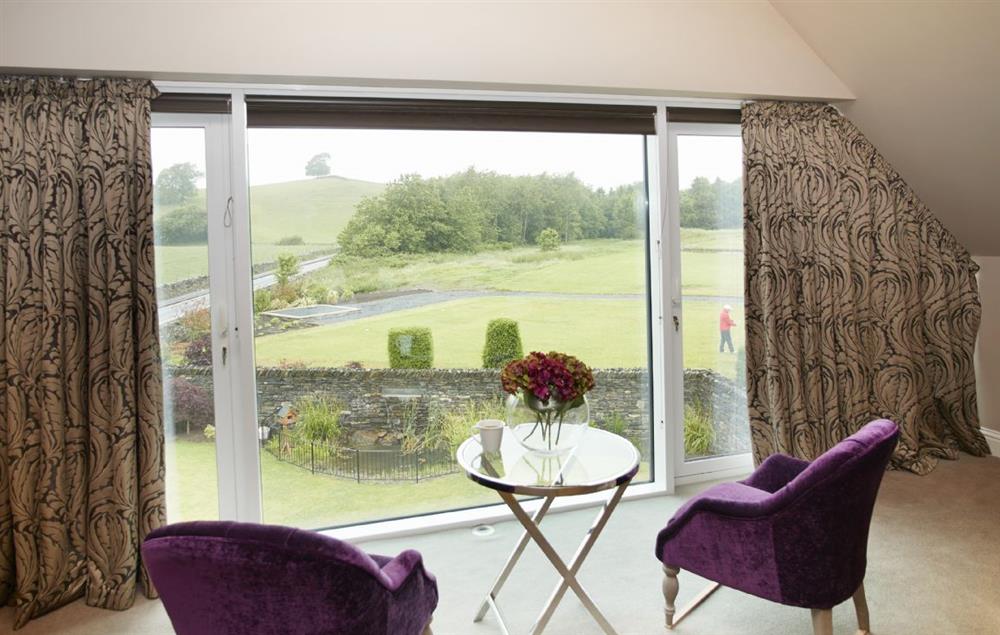 Master bedroom with emperor bed, dressing area and large windows overlooking the golf course (photo 3) at Carus House, Burneside