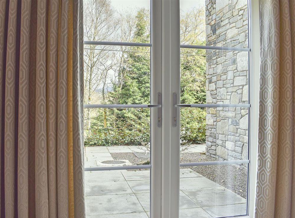 French doors open out to patio with garden furniture at Casa Duran in Killin, Sterlingshire, Perthshire