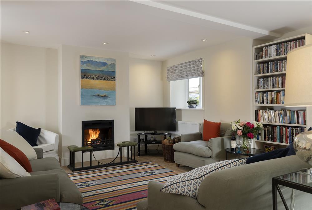 Ground floor: The sitting room with wood burning stove and comfy seating at Cats Abbey Cottage, Northleach