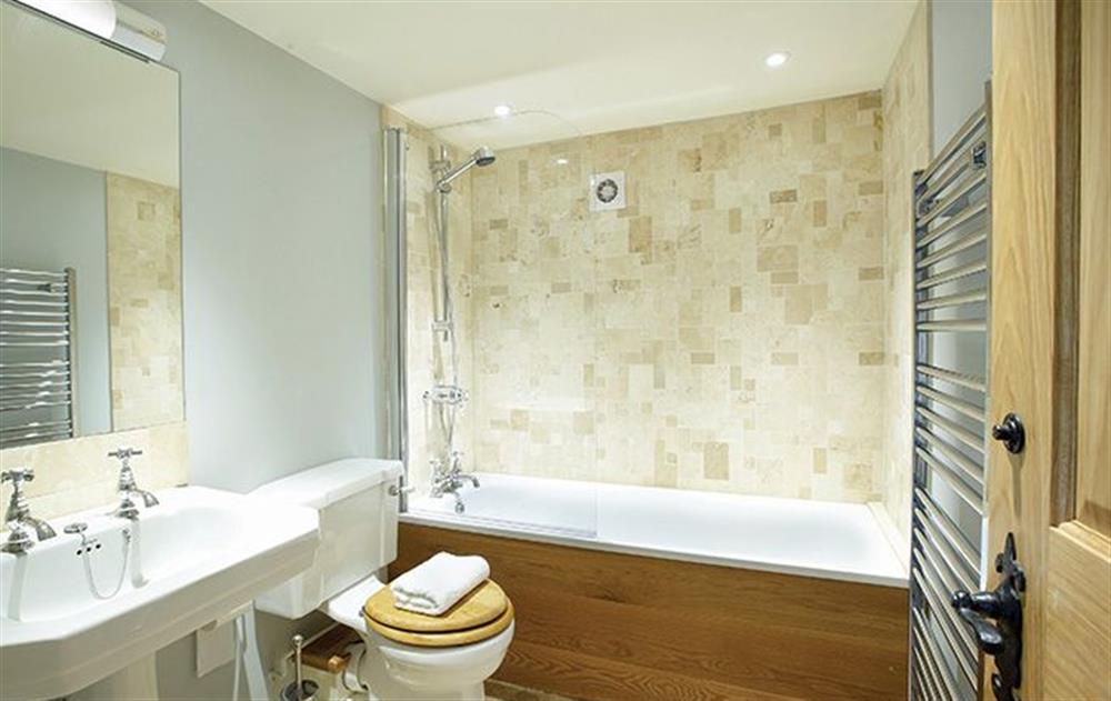 En-suite with bath and shower over to double bedroom with 6’ zip and link bed at Cazenovia Hall, near Greystoke