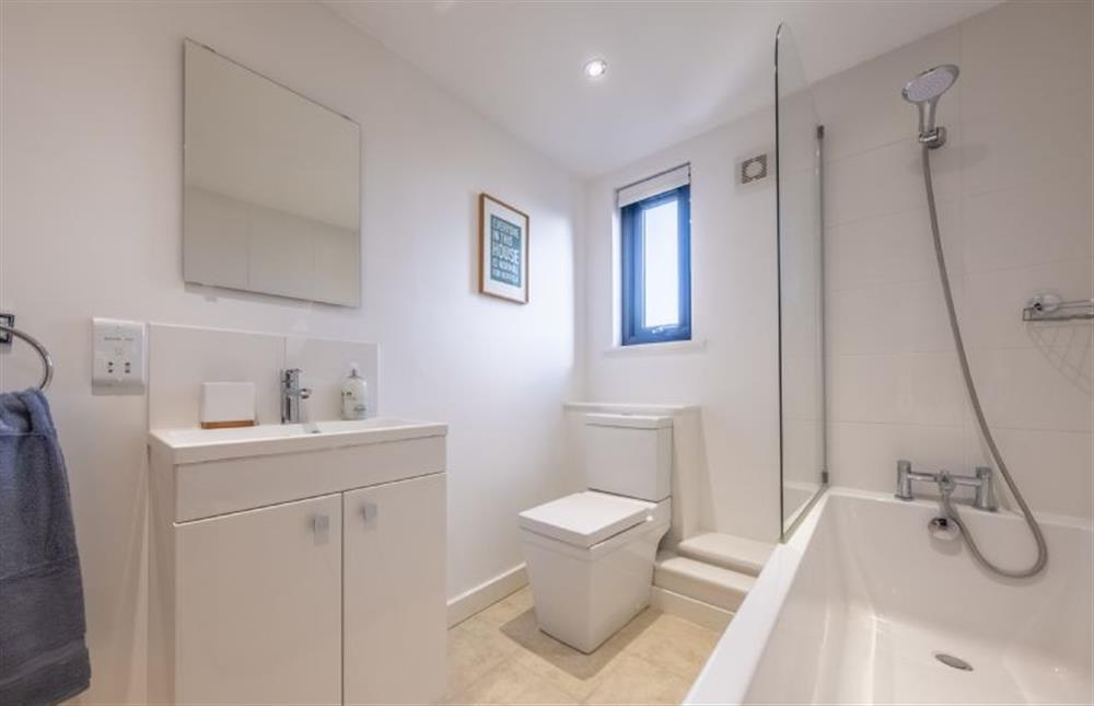 Family bathroom with bath with shower over, wash basin and WC. at Cedar House, Holt