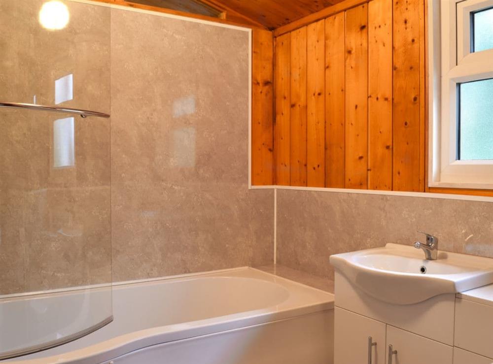 Tiled en-suite bathroom with shower over the bath at Cedar Lodge in Charlcot, near Masham, North Yorkshire