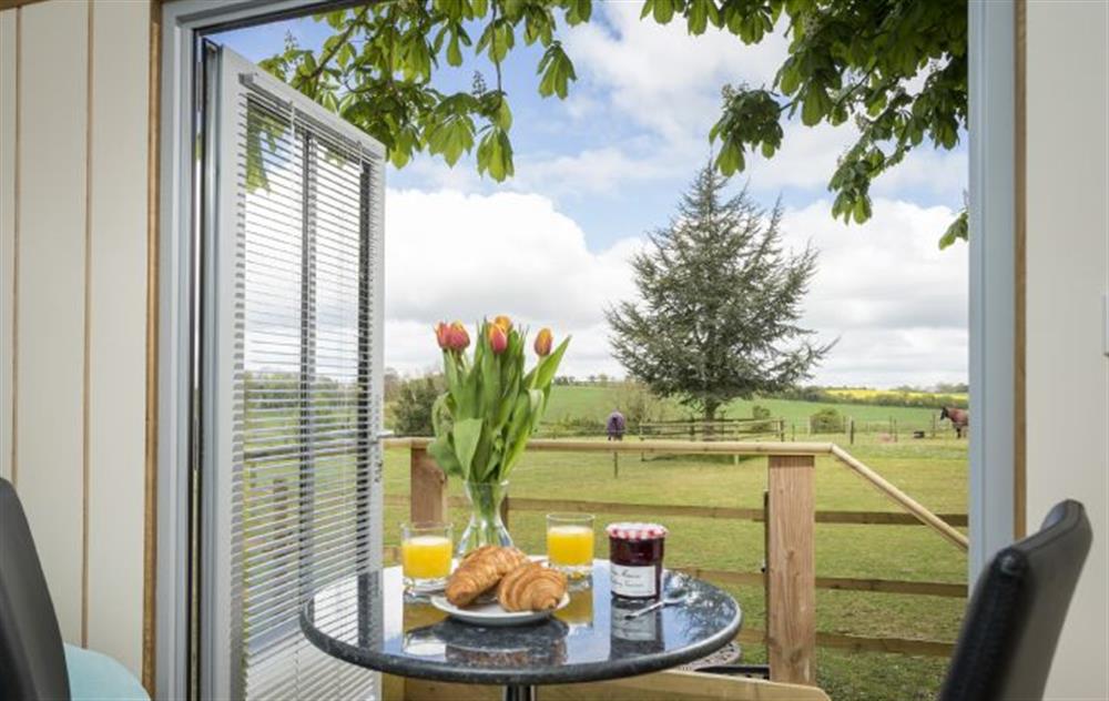 The dining table has glorious views through the french doors on to open countryside at Cedar Tree, Cole Henley