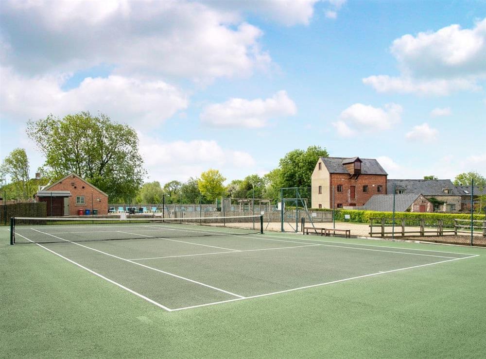 Shared tennis court at Celandine in Somerford Keynes, near Cirencester, Gloucestershire