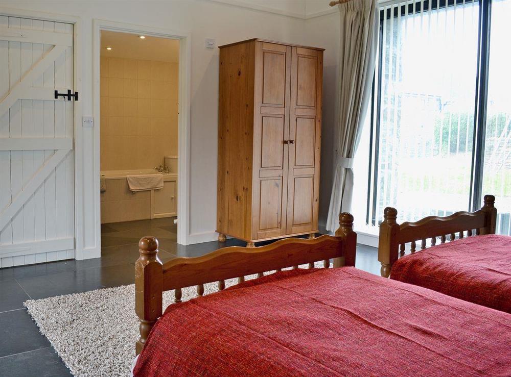 Twin bedroom with fully tiled en-suite bathroom at Long House, 