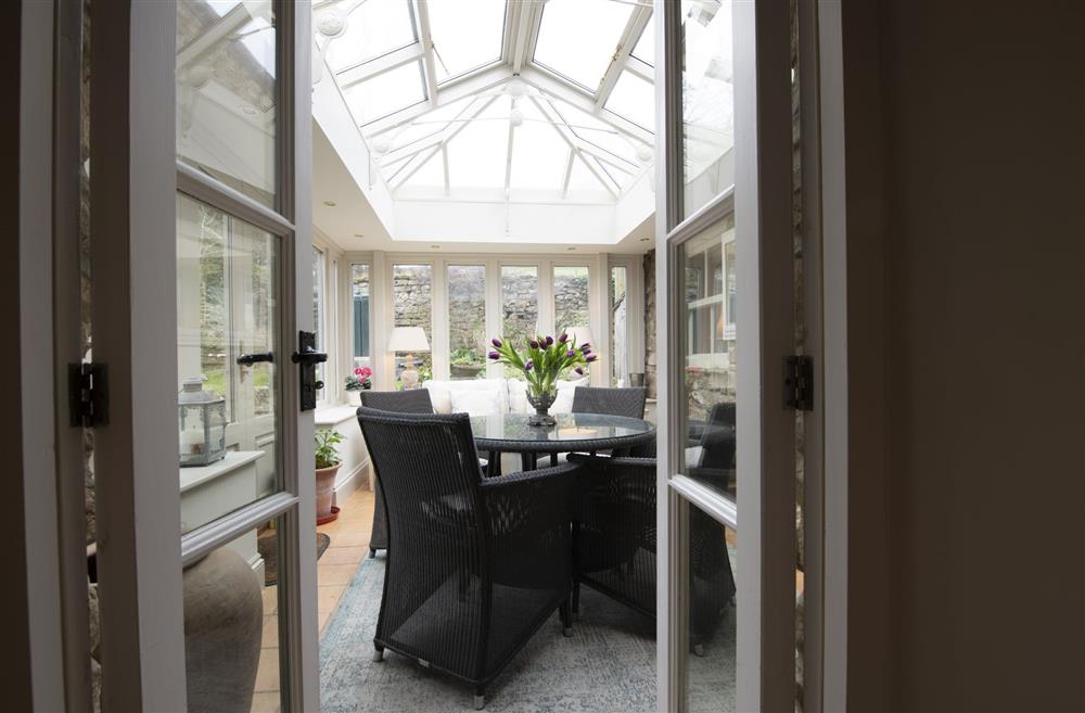 Chance Cottage, North Yorkshire: The conservatory, providing another indoor space with relaxed seating and a dining table and chairs