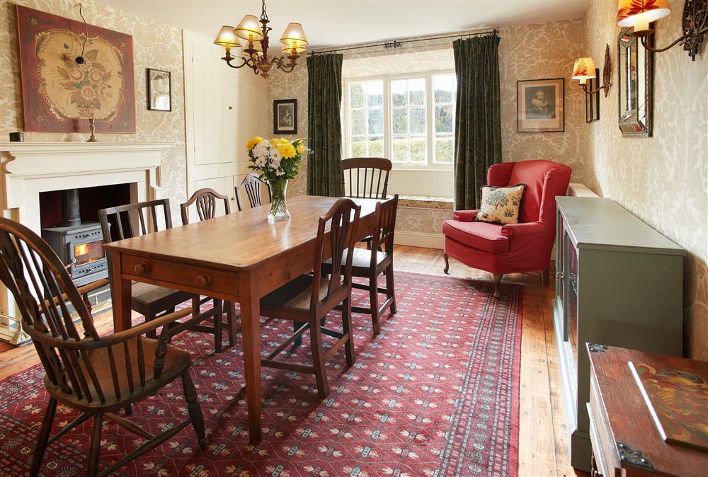 Dining room with wood burning stove and seating for seven guests at Chanting Hill Farmhouse, Castle Howard Estate, Welburn