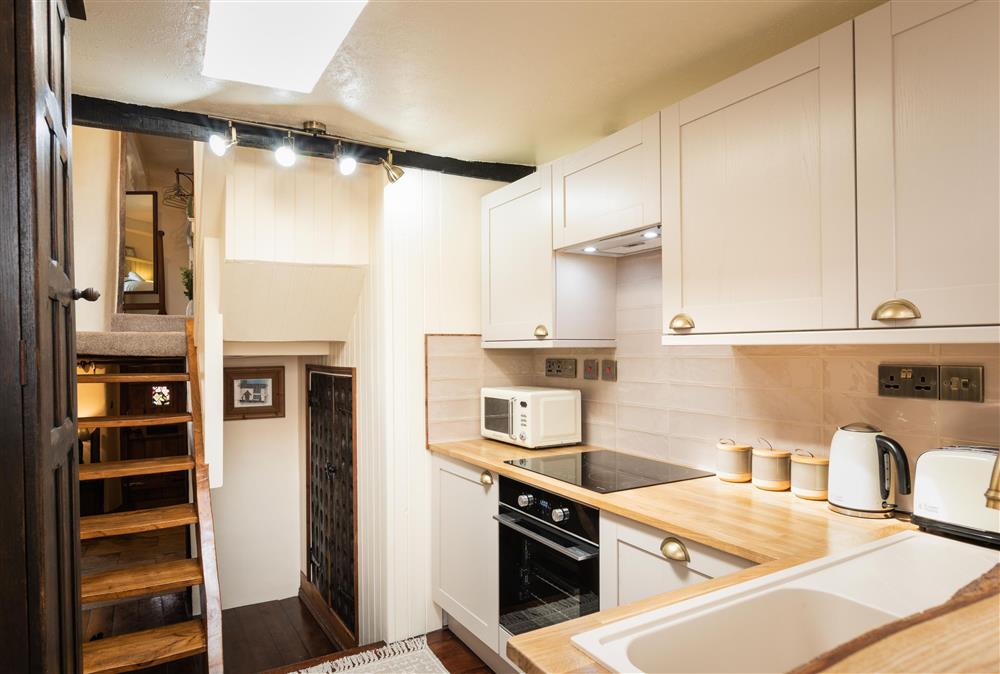 Kitchen with hand-crafted elm stairs leading to the first floor at Chapel Cottage,  Uffculme