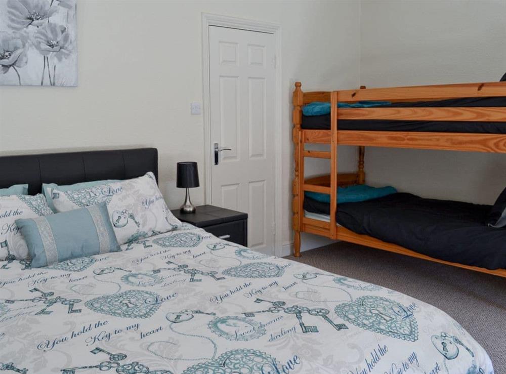 Double bedroom with additional bunk beds at Chapel View in Filey, North Yorkshire
