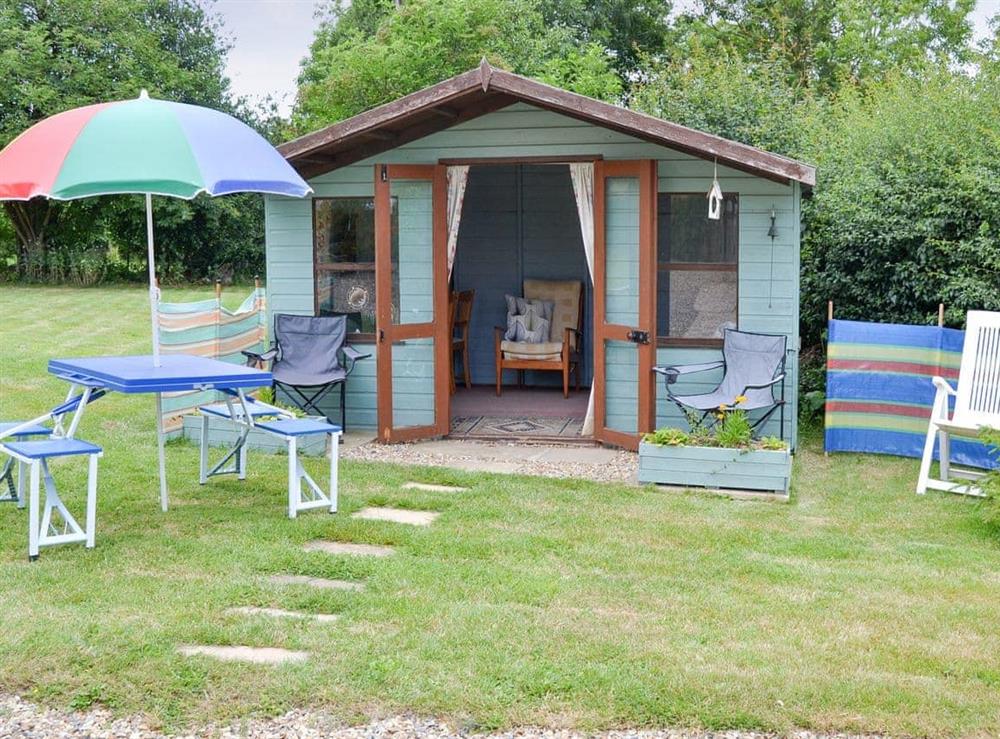 Summerhouse with outdoor furniture at Chapelfield Apartment in Stalham, Norfolk