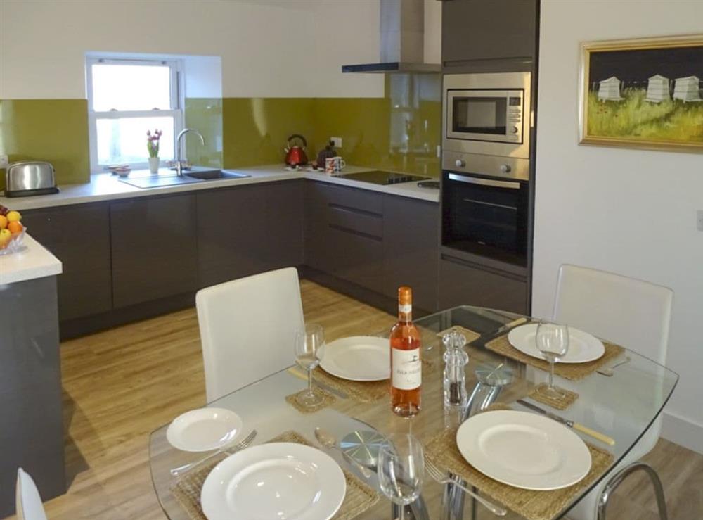 Well-equipped fitted kitchen with dining area at Charlies Cottage in Muasdale, near Campbeltown, Argyll