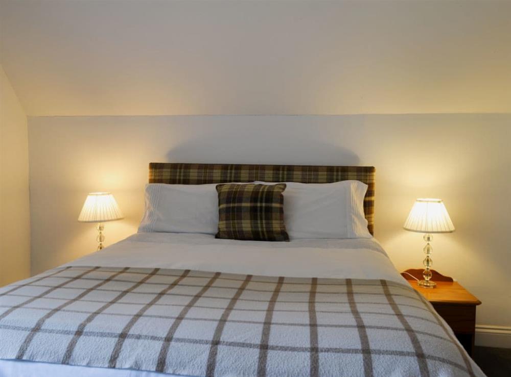 Bedroom with kingsize bed at Checkers Cottage in Beauly, Inverness-Shire