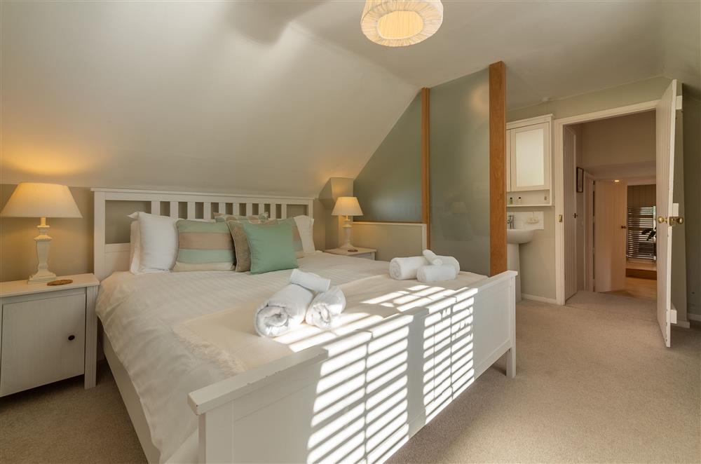Spacious bedroom with 5’ king bed and integrated en-suite bathroom facilities (photo 2) at Cherry Cottage, Ripe