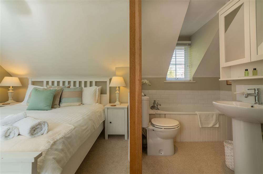 Spacious bedroom with 5’ king bed and integrated en-suite bathroom facilities (photo 3) at Cherry Cottage, Ripe