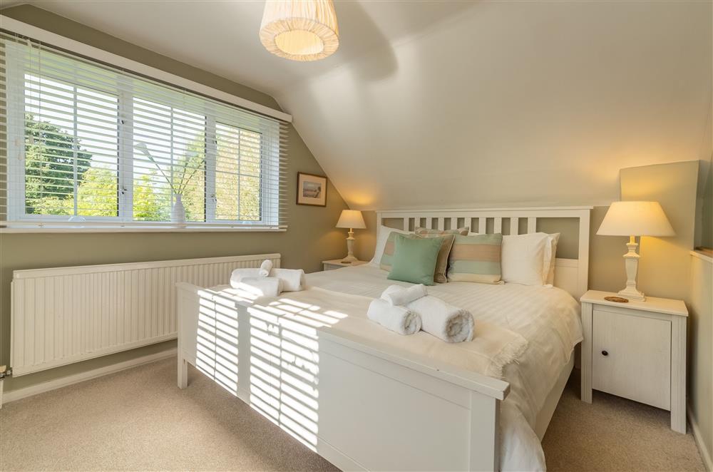 Spacious bedroom with 5’ king bed and integrated en-suite bathroom facilities at Cherry Cottage, Ripe