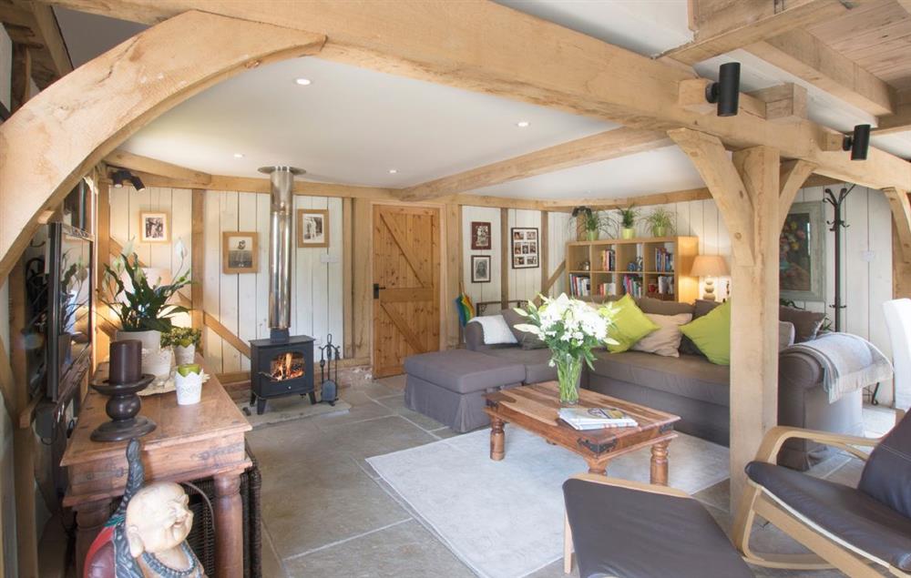 Open plan sitting room with wood burning stove at Cherrystone Barn, Ripe