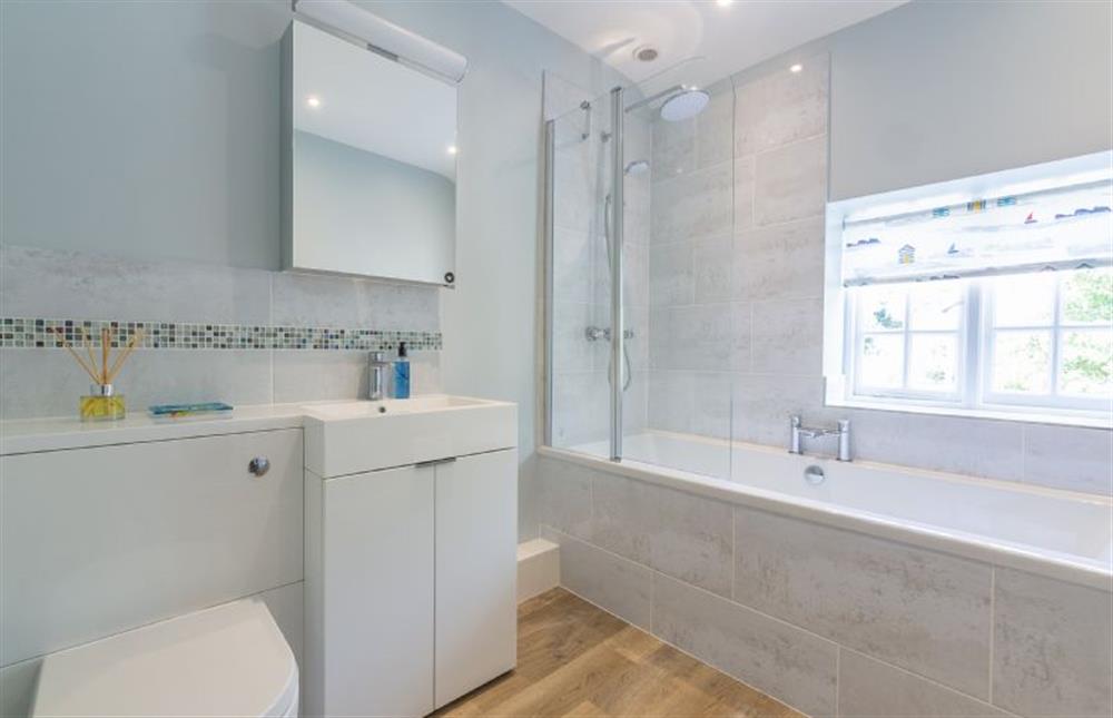 First floor: The family bathroom with a bath with shower over, wash basin and WC at Chestnut Cottage, Thornham near Hunstanton