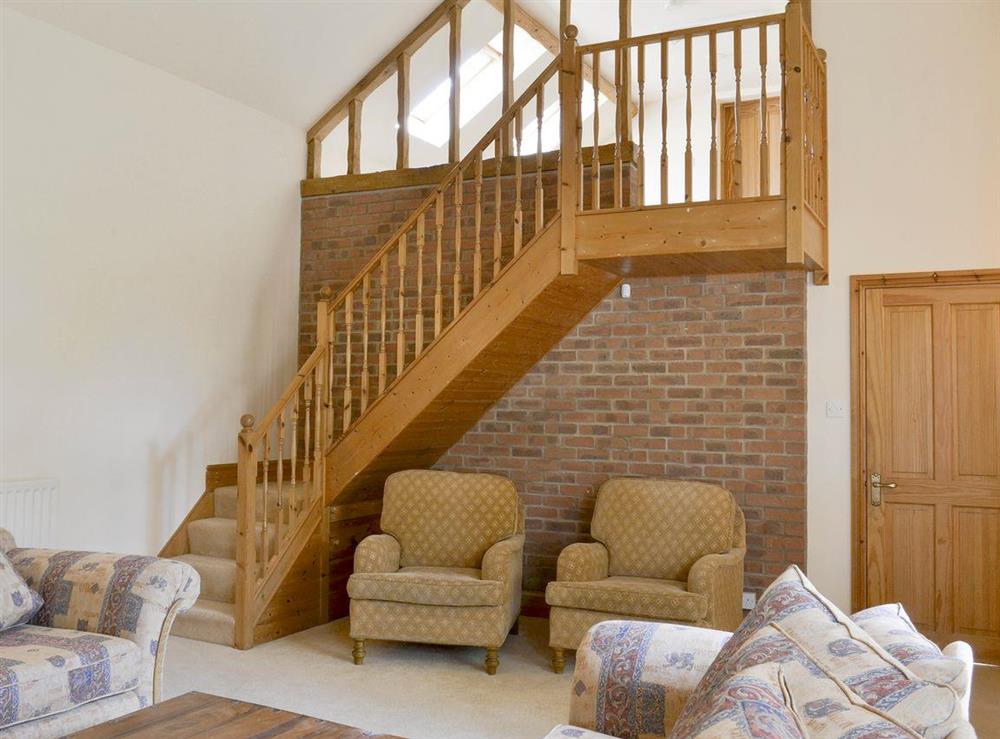 Spacious living room and stairs to first floor at Binbrook House Mews, 