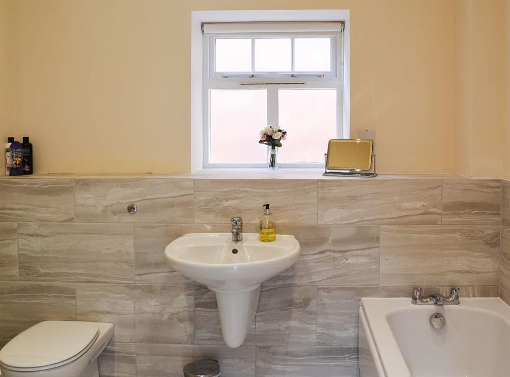 Half-tiled bathroom with heated towel rail at Granary Lodge, 