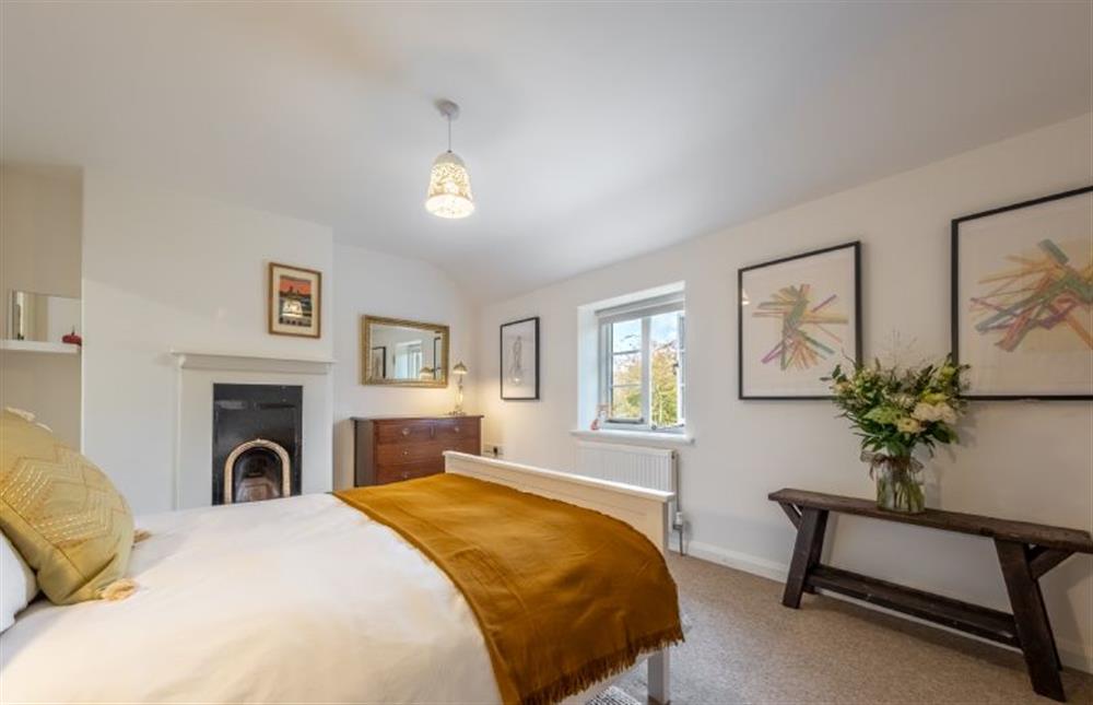 First floor: The master bedroom has a feature fireplace at Chiffchaff Cottage, West Raynham near Fakenham