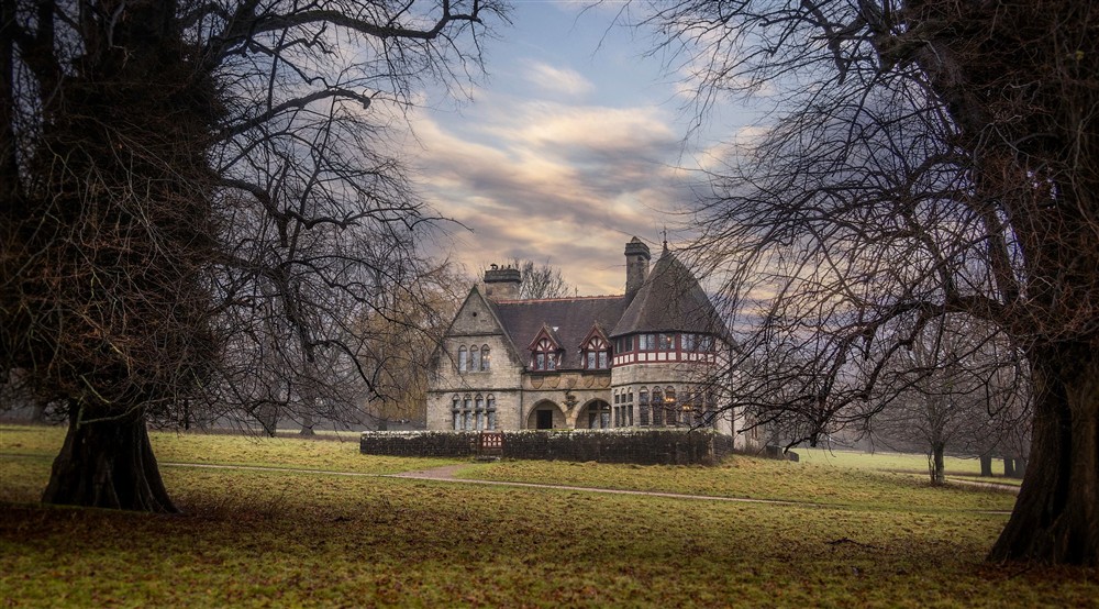 An atmospheric view of the gothic revival style exterior of Choristers House, framed by trees in winter, Yorkshire at Choristers' House in Nr Ripon, North Yorkshire