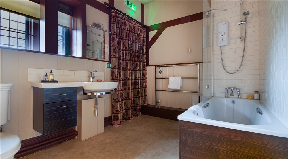 The first floor double bedroom has an en-suite bathroom with shower over the bath at Choristers' House in Nr Ripon, North Yorkshire