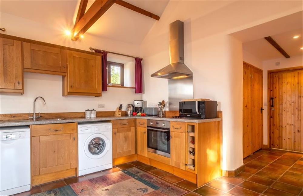 Kitchen with an oven and hob, dishwasher, microwave, fridge, freezer and washing machine at Church Close Cottage, Cusgarne, Truro 