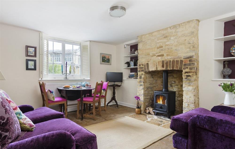 Sitting room with wood burning stove and dining area at Church Cottage, Chipping Norton