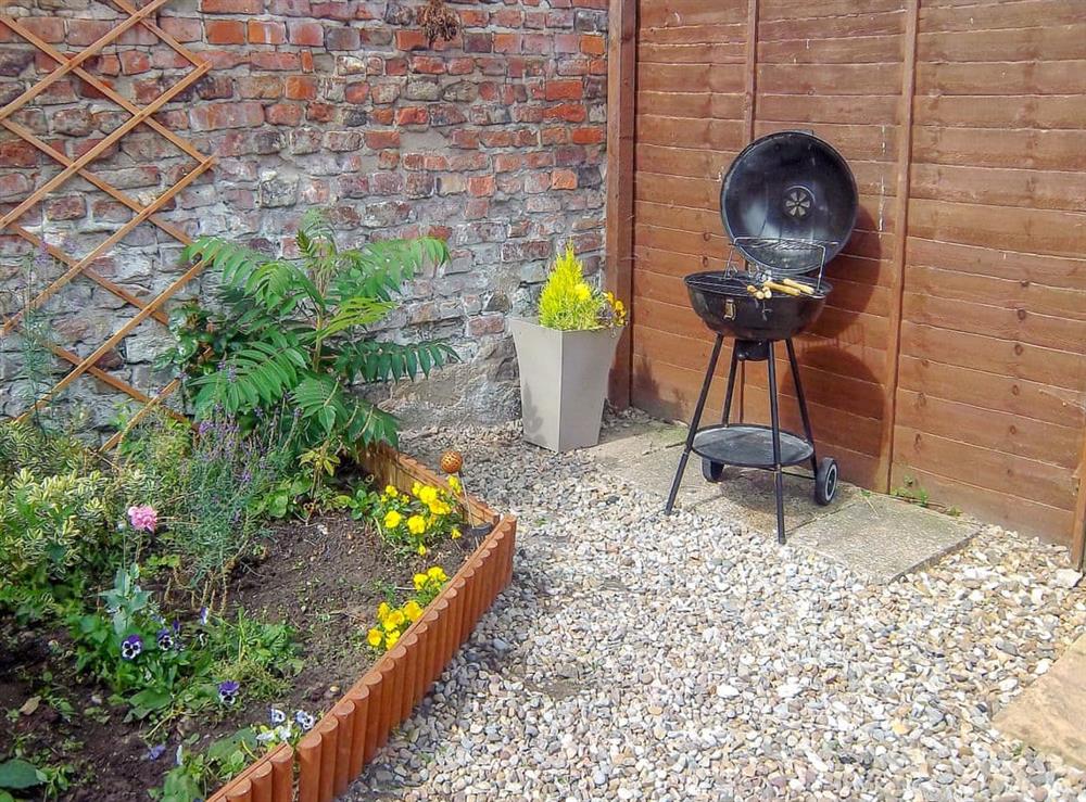 Enclosed courtyard with sitting-out area, garden furniture and barbecue (photo 2) at Church Court Cottage in Beeford, near Driffield, North Humberside