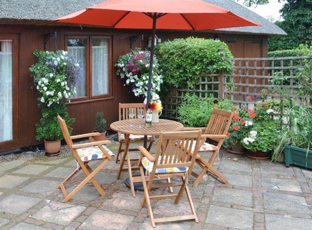 The paved area has a table and chairs for alfresco dining options at Church Farm Studio in Surlingham, Norfolk
