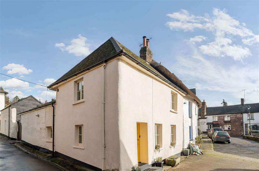 The side aspect of the cottage with view up to the sliding entry gate and parking