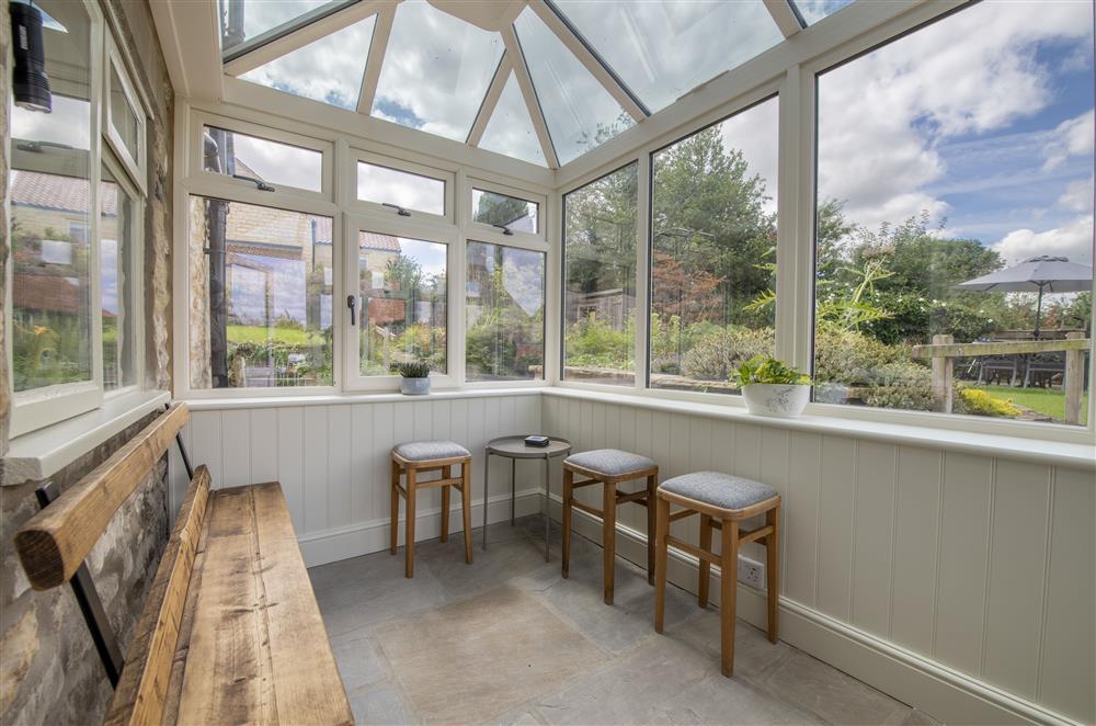 Conservatory with bench seating overlooking the rear garden at Church View, Nunnington
