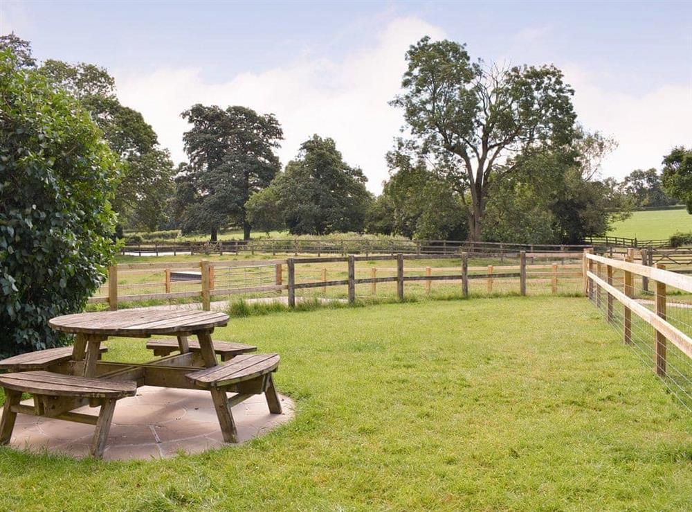 Lawned garden area with outdoor furniture on a paved patio at Churchill Cottage in Glanvilles Wootton, Sherborne., Dorset