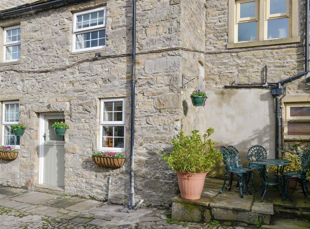Raised stone patio area with outdoor furniture at Churchill House in Grassington, North Yorkshire