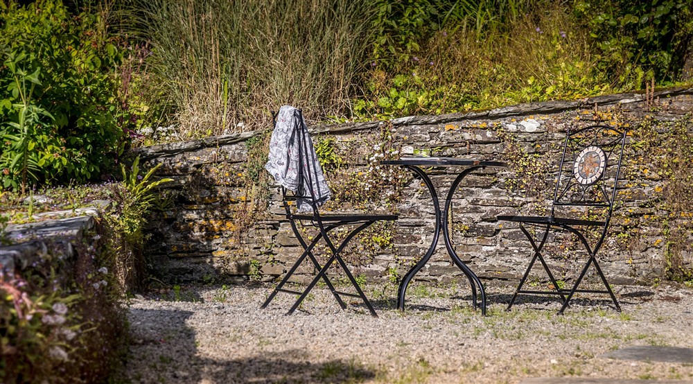 An outdoor table and chairs at Cider Cottage in Yelverton, Devon