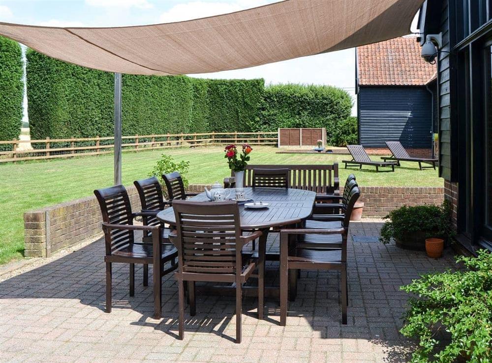 Outdoor seating area overlooking the garden at Clamp Farm Barn in Creeting St Peter, near Stowmarket, Suffolk