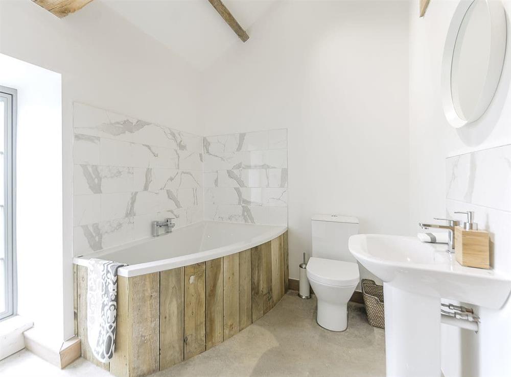 En-suite bathroom with corner bath and shower over the bath at Clawdd-Y-Parc in near Llangybi, Gwent