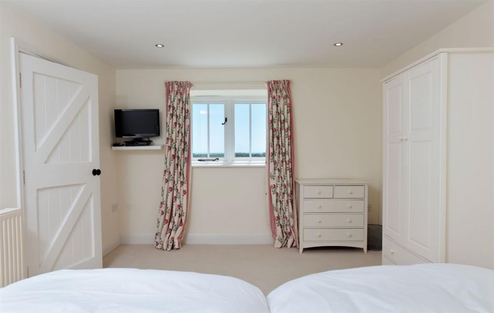 Bedroom two with twin single beds (can be configured as a super-king bed on request) at Clayhanger Lodge, Abbotsbury