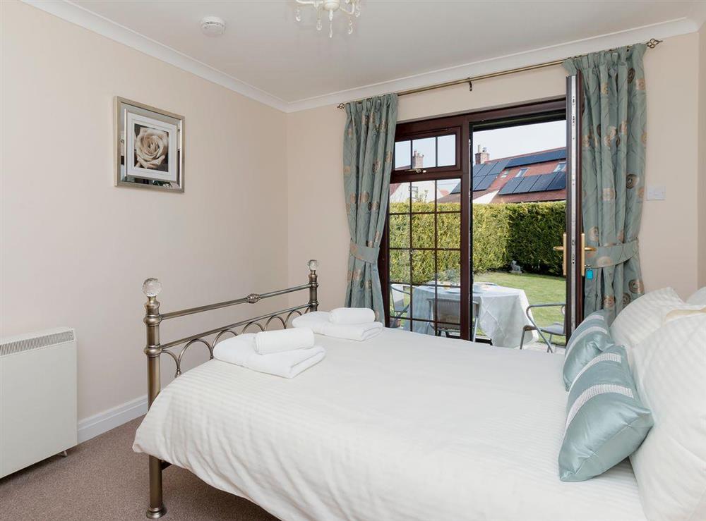 Double bedroom with French doors leading to the garden at Cleets Retreat in Seahouses, Northumberland