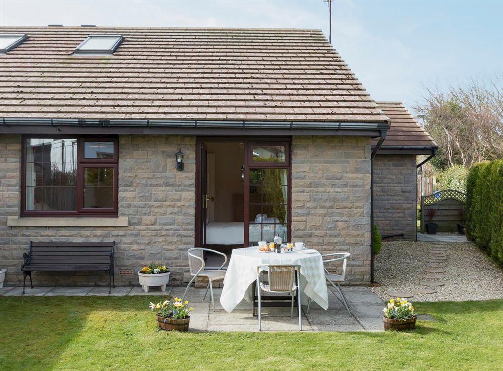 Enclosed lawned garden with sitting-out area and furniture at Cleets Retreat in Seahouses, Northumberland