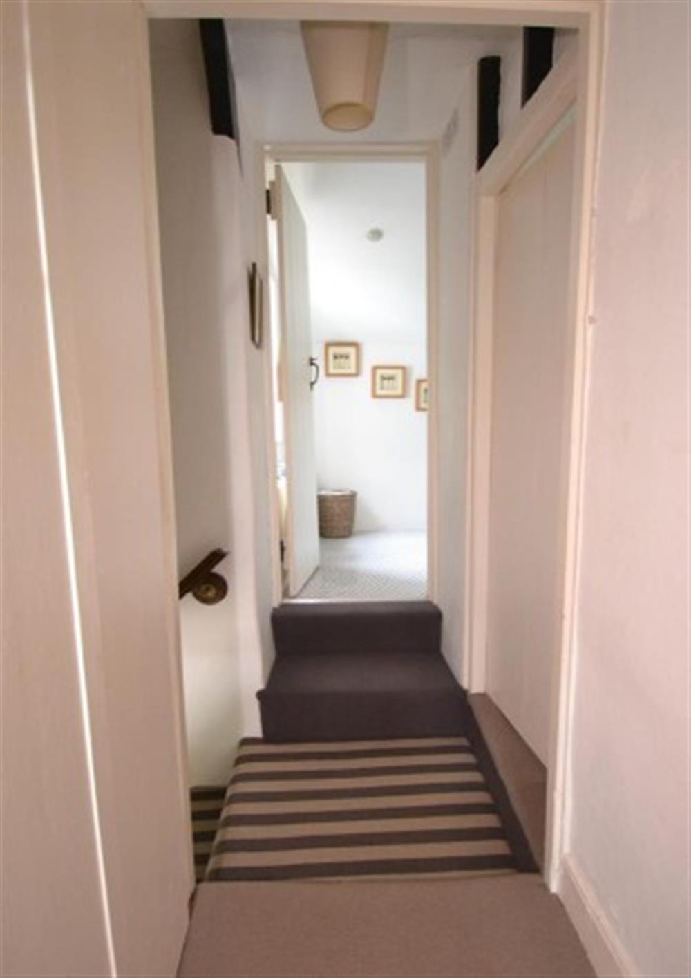 The landing, with steps up to each bedroom and the bathroom at Clematis Cottage in Bantham