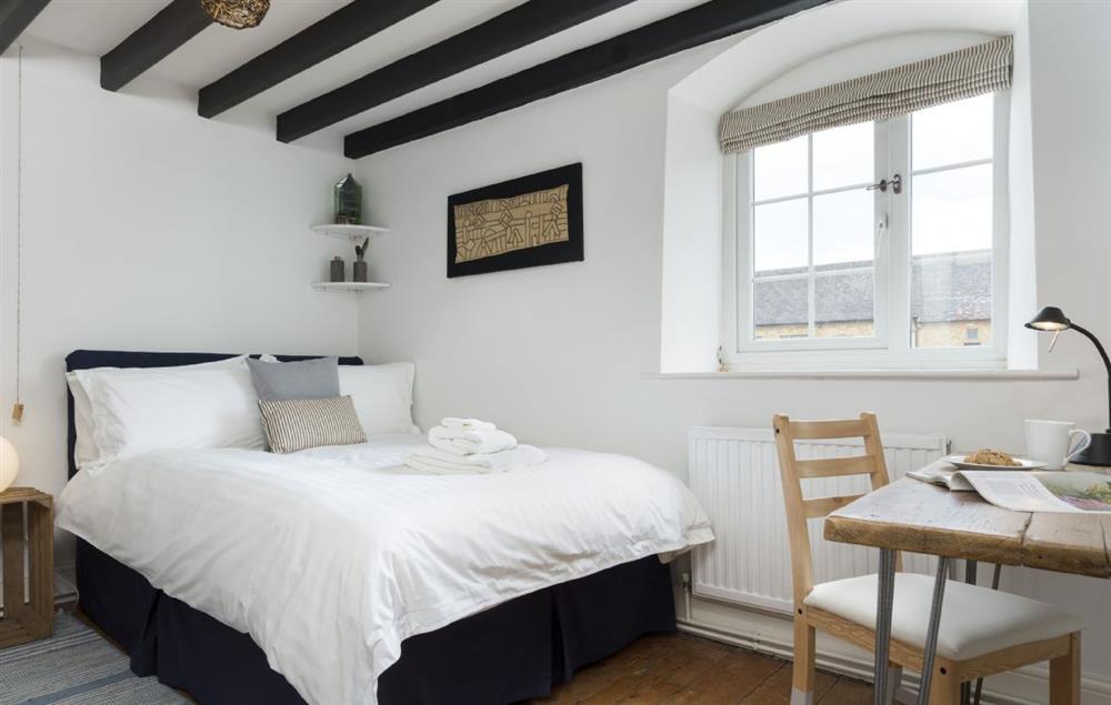 Bedroom with double bed and beamed ceiling at Clematis Cottage, Blockley