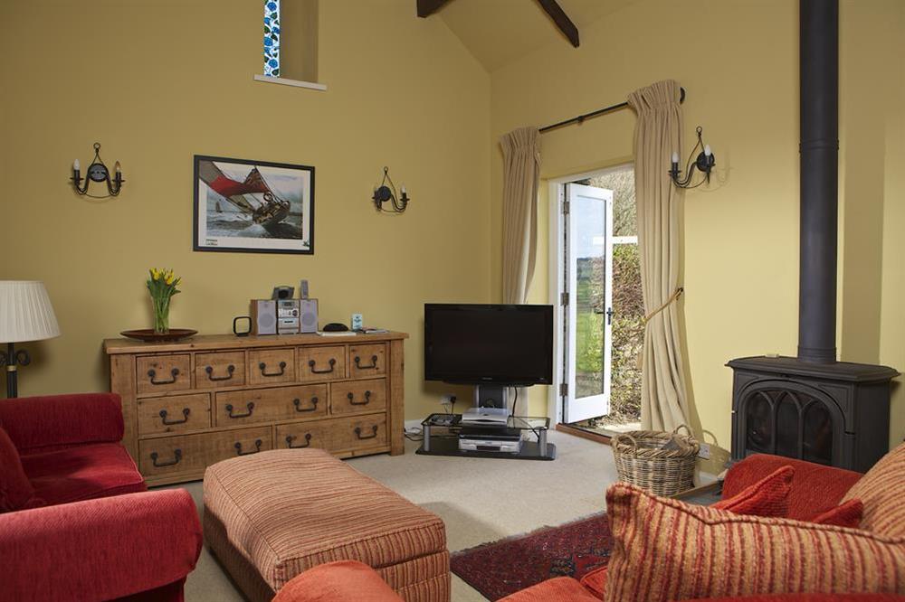 Lounge area with wood burning stove, and doors on to the patio at Clementine Cottage in Malborough, Nr Salcombe