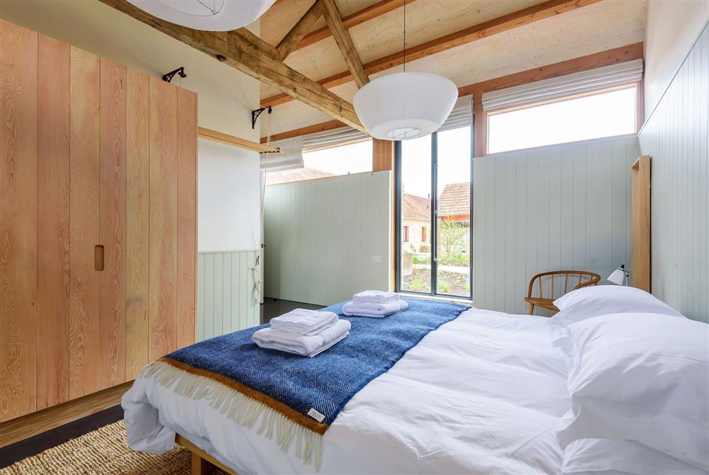 Bedroom one enjoys a 6’ super king-size bed and exposed beams at Clementine, Dorchester